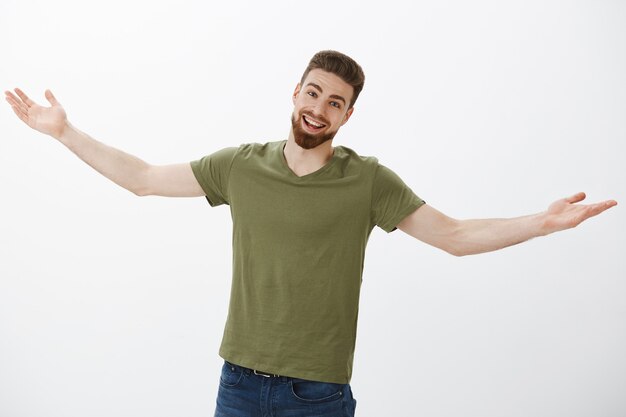 Mate long time no see, give me hug. Portrait of surprised and happy excited good-looking caucasian male with beard smiling friendly with delighted expression stretch hands in welcome and greeting