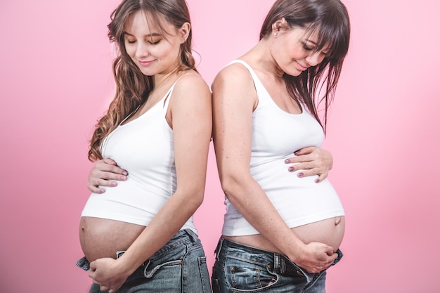 Concetto di maternità, due donne in gravidanza con pancia scoperta