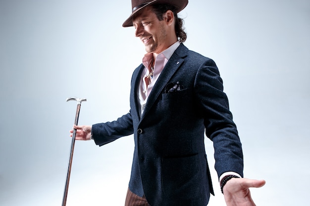 Free photo the mature bearded man in a suit and hat holding cane.