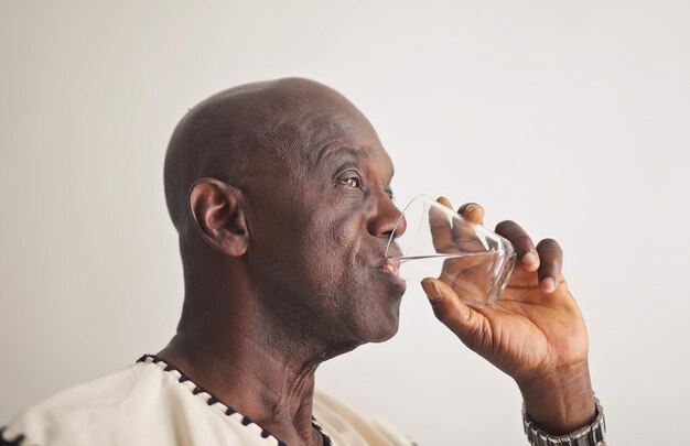 Зрелый черный мужчина пьет воду