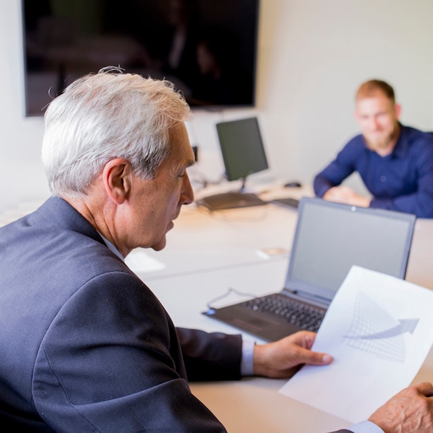 Mature businessman analyzing graph in the office