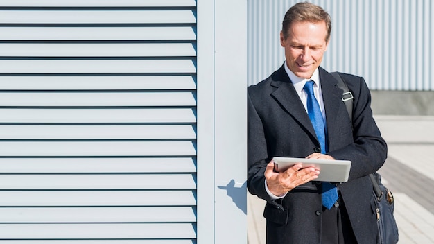 Mature businessman using digital tablet at outdoors