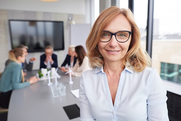 Donna d'affari matura che conduce durante la riunione d'affari