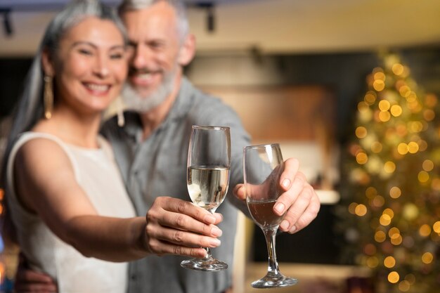 Пожилая пара, наслаждаясь напитками на новогодней вечеринке