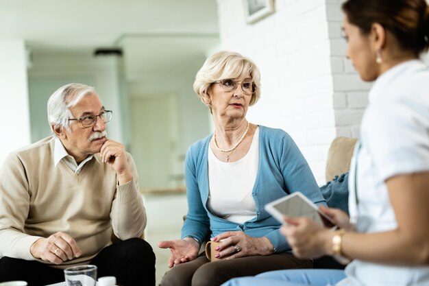Пожилая пара разговаривает с домашним опекуном об их состоянии здоровья дома