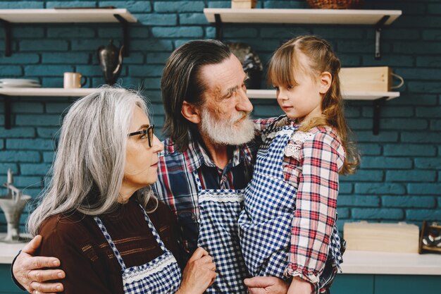 Mature couple and their granddaughter preparing food