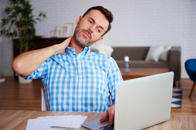 Mature entrepreneur suffering from neck pain