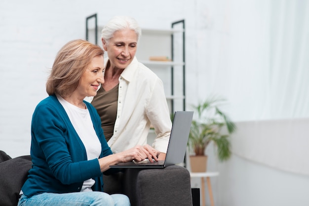 Mature friends browsing on a laptop