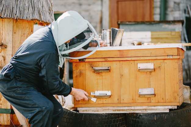 A mature man beekeeper works on a beehive near the hives. Natural honey directly from the hive.