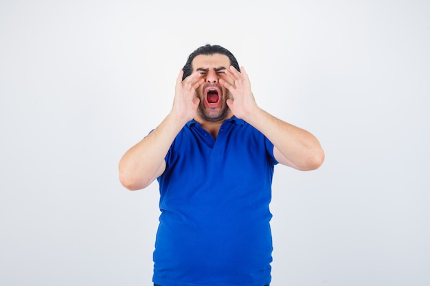 Mature man holding hands near mouth as calling someone in blue t-shirt