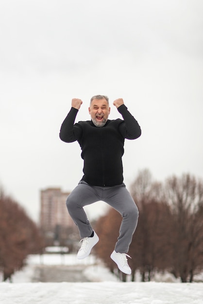 Free photo mature man jumping of happiness