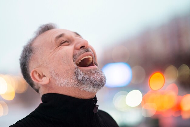 Mature man laughing outside close-up
