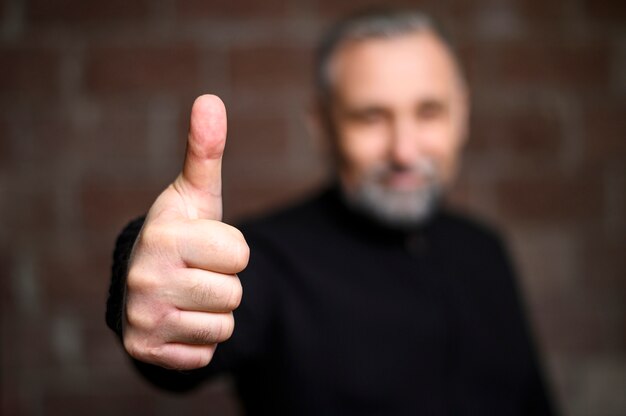 Mature man making the thumbs up sign