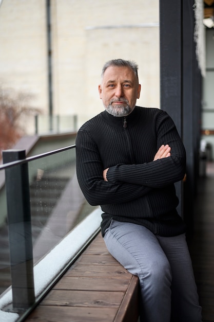 Mature man sitting on a sill