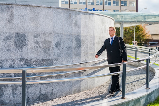 Mature man walking near railing at outdoors