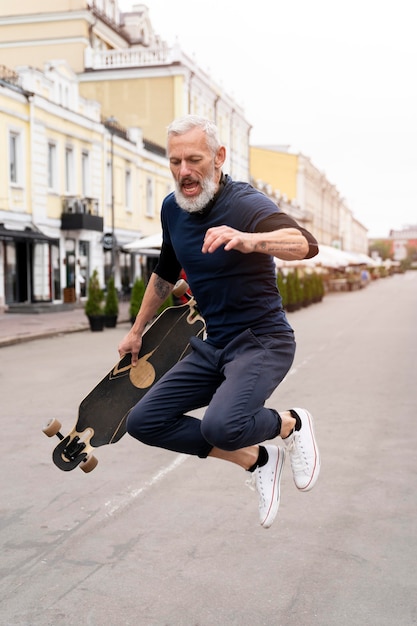 Uomo maturo con skateboard mobilità sostenibile