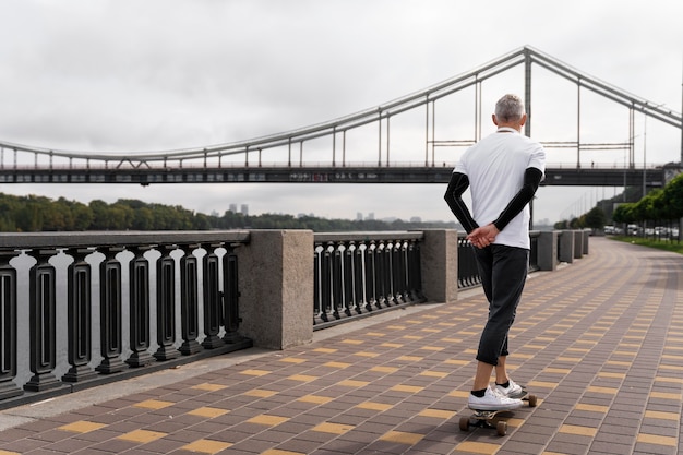 Mature man with sustainable mobility skateboard