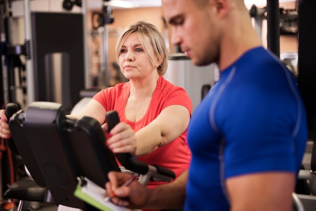 Mature woman doing exercising with trainer