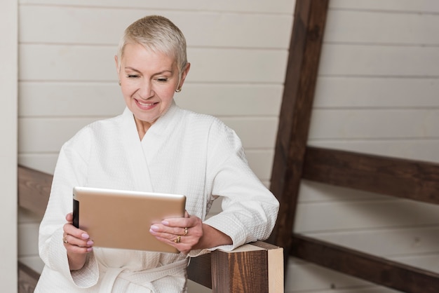 Free photo mature woman looking on her tablet at home