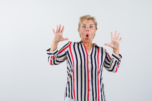 Free photo mature woman showing palms and surrendering