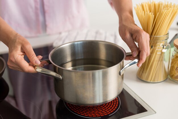 キッチンの料理に立っている熟女。