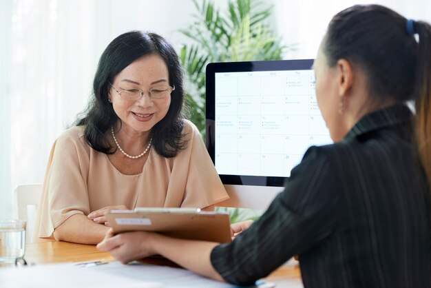 Mature woman talking to insurance agent
