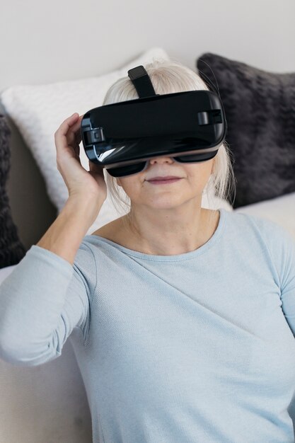 ソファー、VRヘッドセットの中年女性