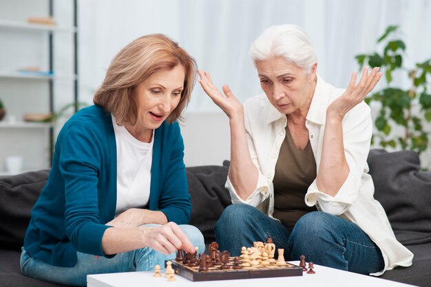 Mature women playing chess together