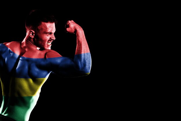 Mauritius flag on handsome young muscular man black background