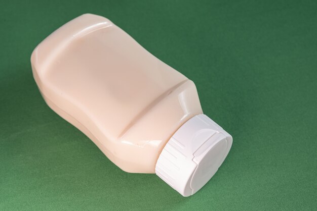 Mayonnaise container on the green surface