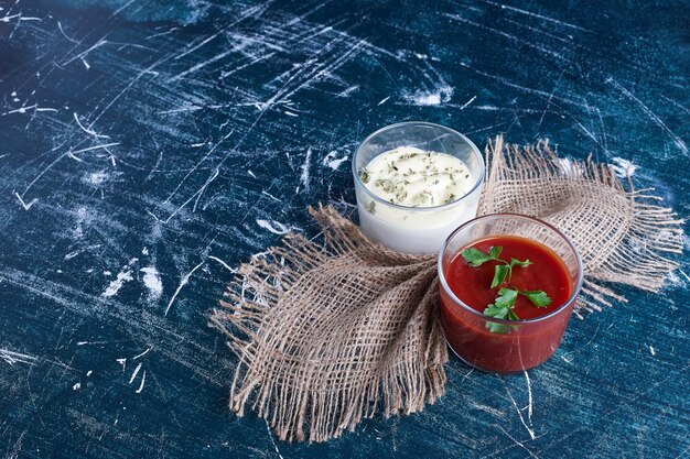 Mayonnaise and ketchup in glass cups .