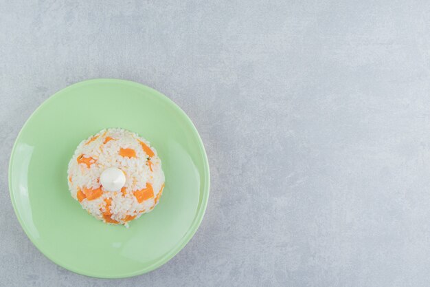 Mayonnaise on the rice in the plate , on the marble background.