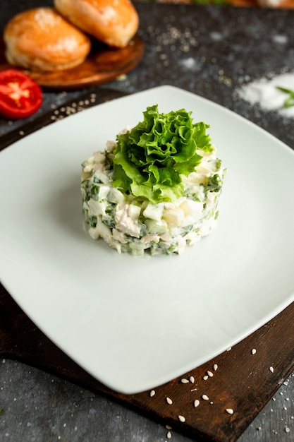 Foto gratuita insalata di maionese con lattuga su un piatto bianco