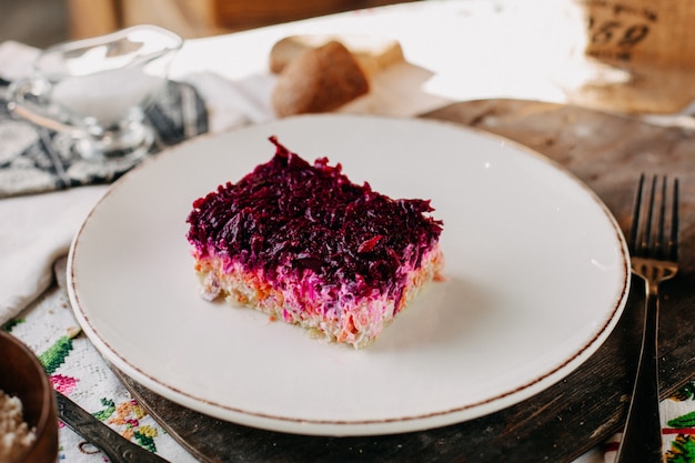 mayyonaise salad with sliced beet purple vegetables salted peppered chicken inside white plate