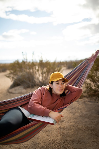 Free photo mdium shot woman laying on hammock