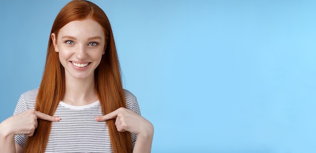 Free photo me seriously glad surprised happy carefree redhead tender feminine girl pointing herself smiling