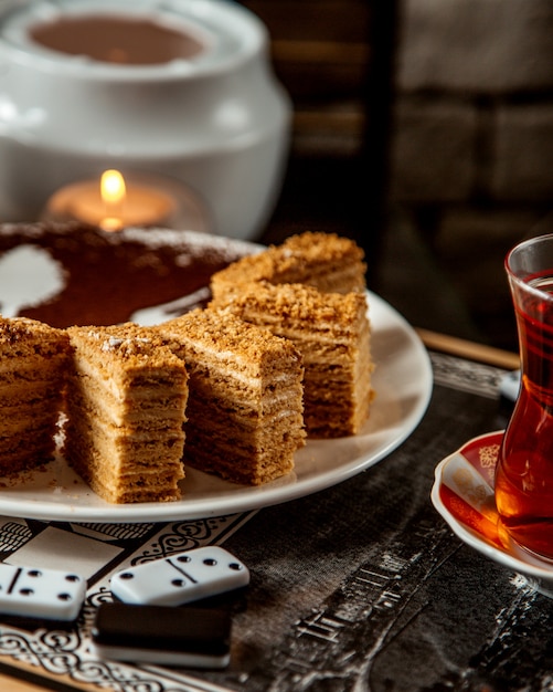 Бесплатное фото Медовый пирог нарезанный на кусочки и черный чай