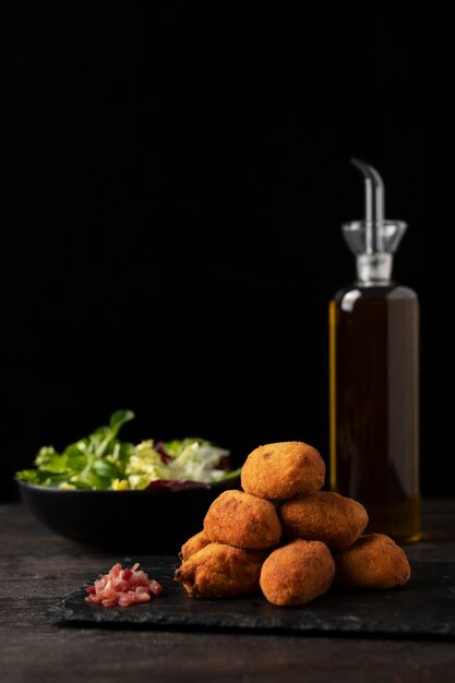 Meal containing croquettes with bacon and salad