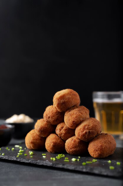 Meal containing croquettes with parsley and a glass of beer