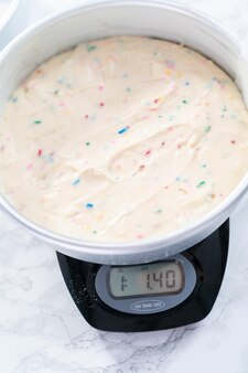 Measuring cake batter by weight on a digital kitchen scale.