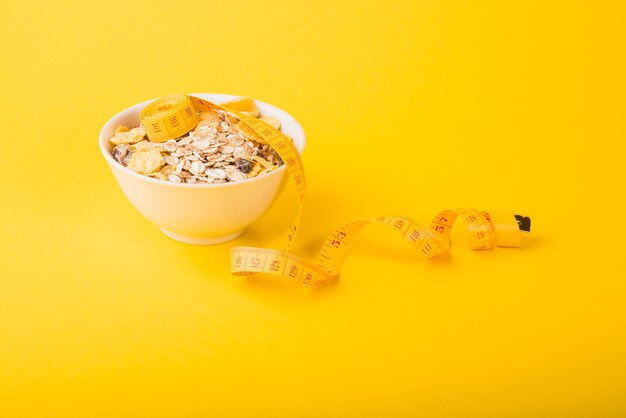 Measuring tape near bowl of flakes