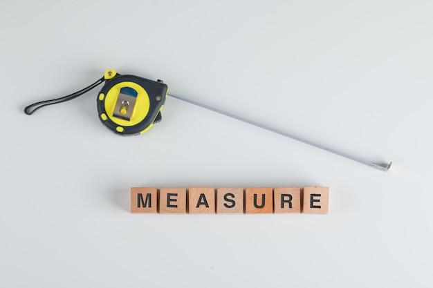 Measuring tape and wooden cubes with the text measure