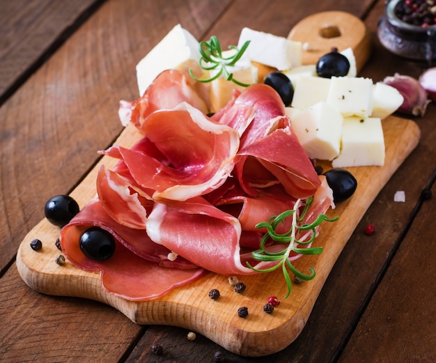 Meat appetizer on a plate on old wooden background