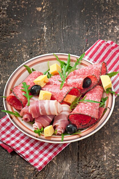 Meat appetizer on a plate on old wooden surface