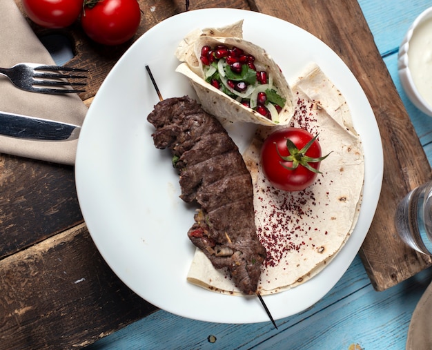 Meat barbecue served with vegetables salad served in lavash