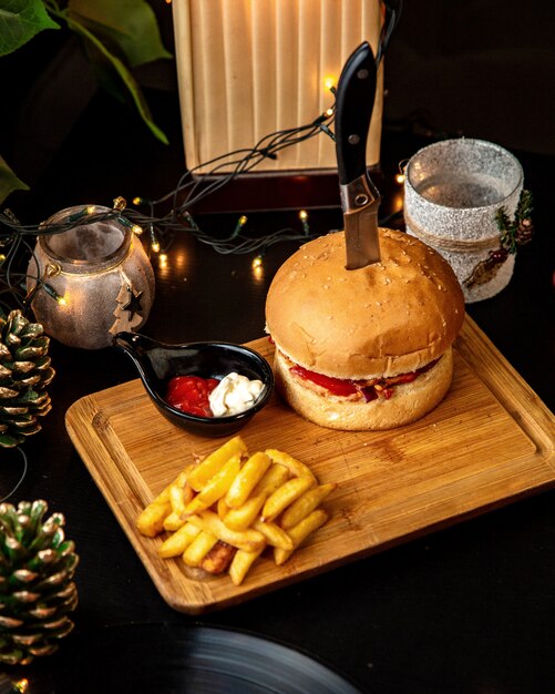 Meat burger served with french fries and sauces