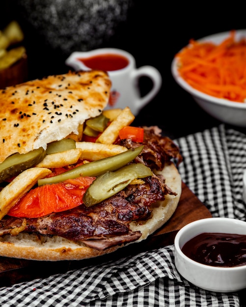 Meat doner in bread with french fries and pickles