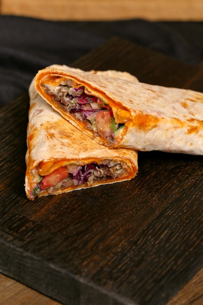 Meat doner in pita bread on a wooden board