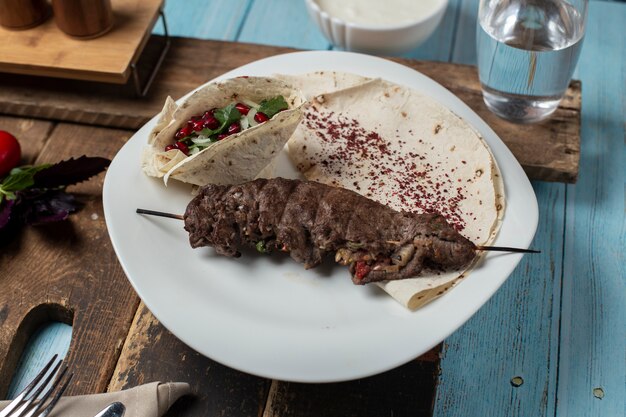 Meat kebab in lavash with herbs and spices.