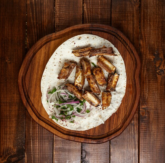 Meat kebab set on wooden board top view